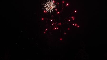 glowing fireworks show. colored night explosions in black sky. beautiful multi colored fireworks in night sky. New years eve fireworks celebration. shining fireworks with bokeh lights in the night sky.の写真素材