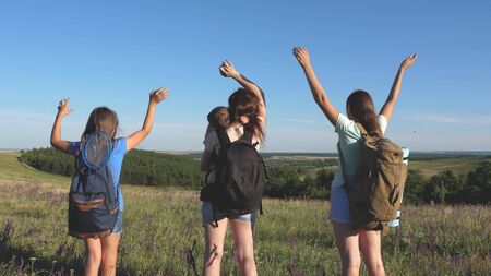 women travelers raise their hands and rejoice. Mom and children are tourists. teamwork travelers....