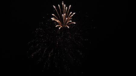 beautiful multi colored fireworks in night sky. New year's eve fireworks celebration. shining fireworks with bokeh lights in night sky. glowing fireworks show. colored night explosions in black skyの写真素材