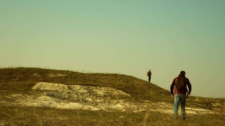traveler with a backpack goes on meeting with another traveler. sports tourism. collaboration of business people. The team of travelers goes to victory and success. team work in business.の写真素材