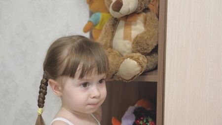 little happy girl actively play with plush toys and teddy bears. the child plays in the childrens room. the kid loves to play his toys. concept of childhood and familyの写真素材