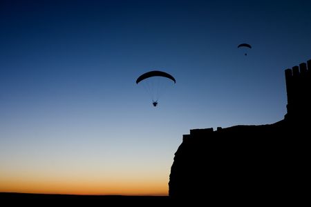 Photo taken in the province of Albacete at the dusk, near a castle in which a group of sportsmen was practicing the paraglidingの写真素材