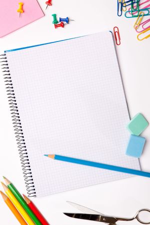 Set of pencils, erasers, post-its and other useful supplies for the school. There is a centered blank notebook for text writingの写真素材