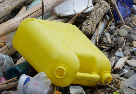 Yellow plastic tank drifting on the shoreの写真素材