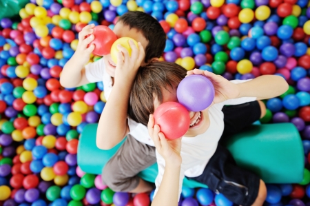 Happy children playing and having fun at kindergarten with colorful balls on eyesの写真素材