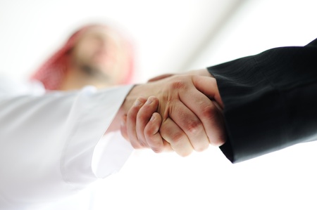 Successful Arabic business people shaking hands over a dealの写真素材