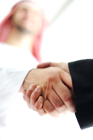 Successful Arabic business people shaking hands over a dealの写真素材