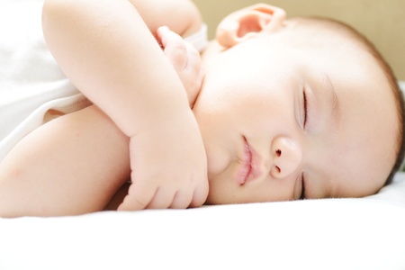 Baby sleeping on white sheet