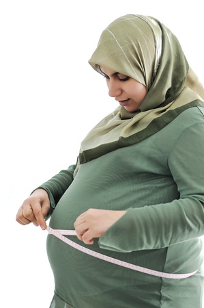 Pregnant woman measuring her belly の写真素材