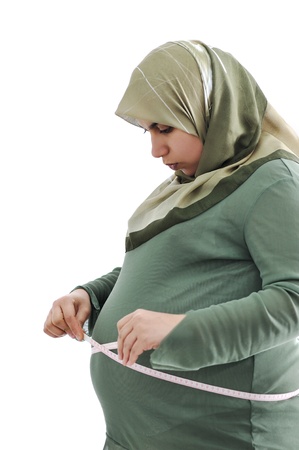 Pregnant  muslim woman measuring her belly の写真素材