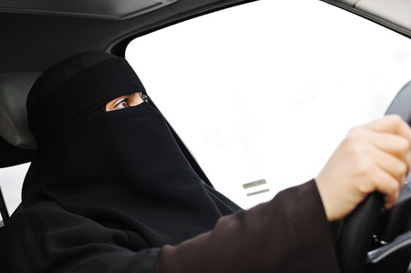Arabic Muslim woman with veil and scarf (hijab and niqab) driving carの写真素材