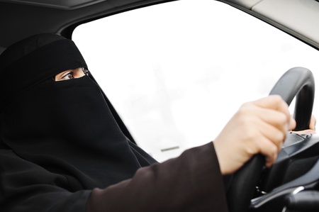Arabic Muslim woman with veil and scarf (hijab and niqab) driving carの写真素材