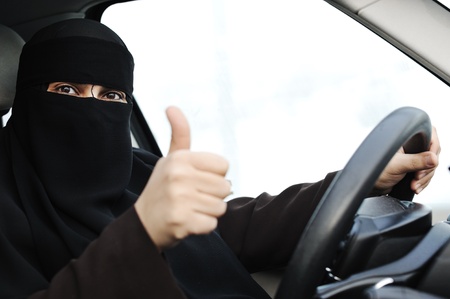 Arabic Muslim woman with veil and scarf (hijab and niqab) driving carの写真素材
