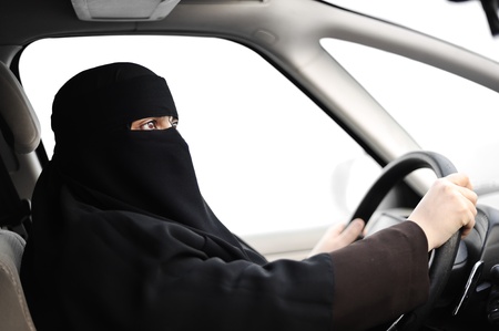 Arabic Muslim woman with veil and scarf (hijab and niqab) driving carの写真素材