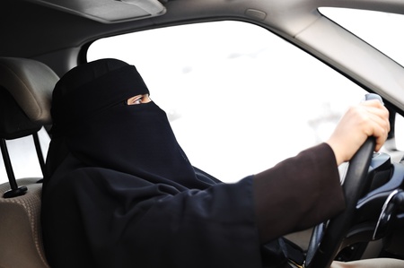 Arabic Muslim woman with veil and scarf (hijab and niqab) driving carの写真素材