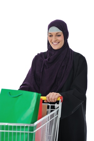 happy muslim woman with shopping cart  over whiteの写真素材