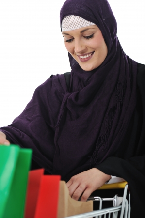 happy muslim woman with shopping cart  over whiteの写真素材