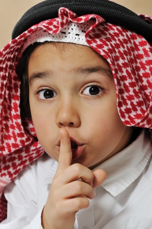 Cute arabian kid asking for silence, secretの写真素材