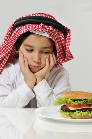 Unhappy Arabic kid with burgerの写真素材