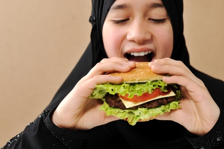 Arabic girl eating burgerの写真素材
