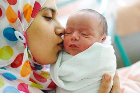 Beautiful new born baby in his mothers hands.