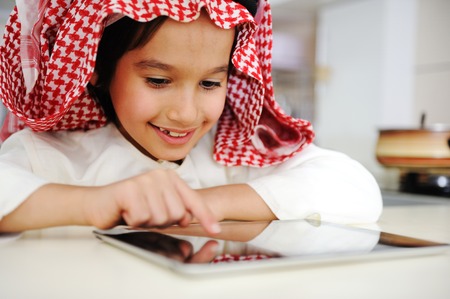 Arabic little boy playing on tablet の写真素材