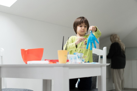 Little boy at home drawing and playingの写真素材