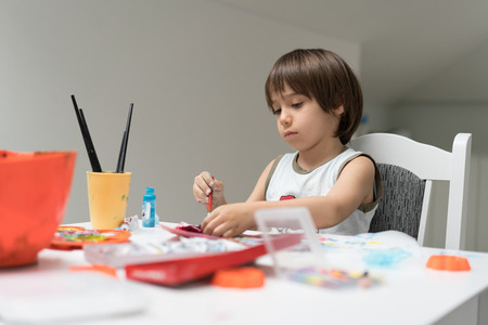 Little boy at home drawing and playingの写真素材