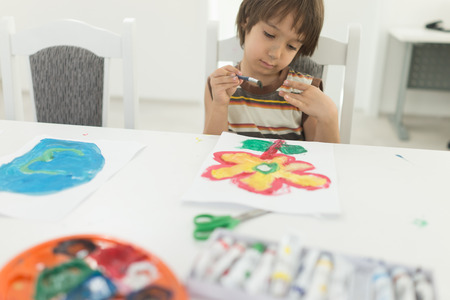Little boy at home drawing and playingの写真素材