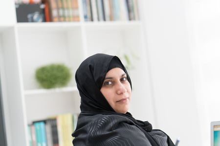 Young Muslim Woman Wotking on Laptop on Deskの写真素材