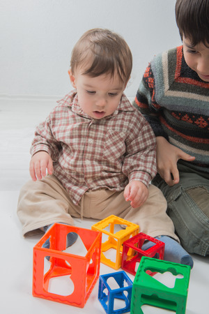A Cute Baby Toddler Playing with His Brotherの写真素材