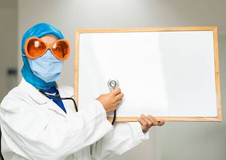 Muslim female doctor with blank whiteboardの写真素材