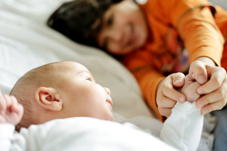 Little boy playing with his new newborn baby brotherの写真素材