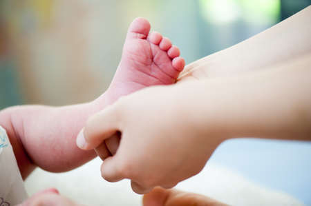 Feet of a newborn baby . Happy Family ,Mum and Dad hug their babys legs.High quality photo