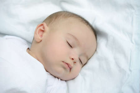 Baby sleeping on white sheet high quality photos