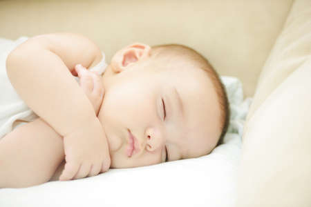 Baby sleeping on white sheet