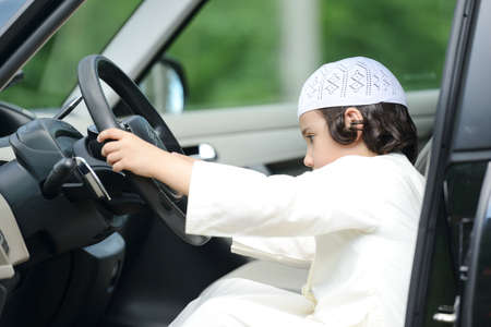 Arabian kid playing as driving a carの写真素材