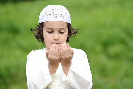 A little Arabic boy praying outdoor in natureの写真素材