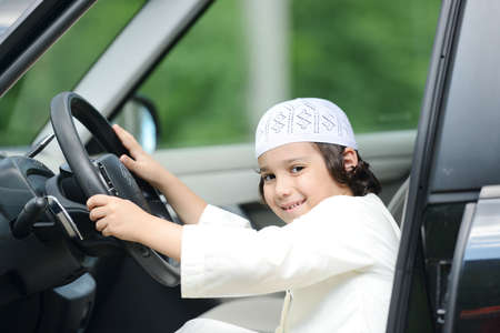 Arabian kid playing as driving a carの写真素材