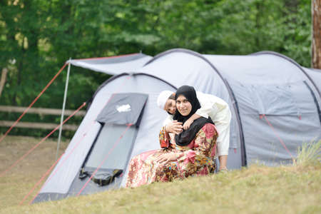 Muslim woman with her son camping in natureの写真素材