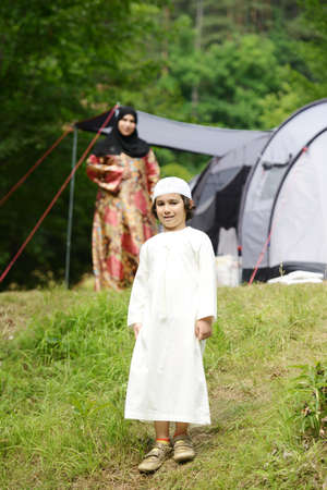 Little Arabic kid camping in nature with family