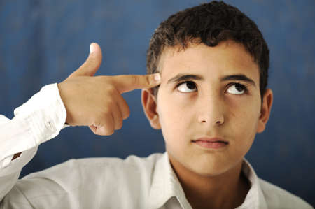 Kid with finger on his foreheadの写真素材