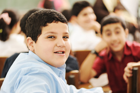 Happy children with their teacher in classroom, doingの写真素材