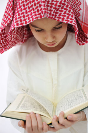 Muslim Arabic little boy reading Koranの写真素材