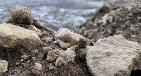 Rock Formation by Beach With Water in Background