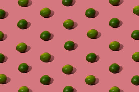 Organic green lime pattern on a pastel pink background. Hipster flat lay concept.の写真素材