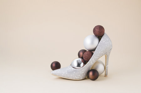 Elegant visual of a luxury shoe with Christmas baubles. Beige background minimal concept.の写真素材