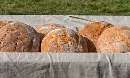 A lot of fresh bread lies in the cart on sunny day outdoors.の写真素材