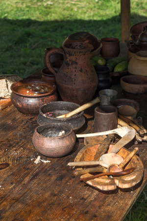 Ancient wooden and clay dishes left on the table after dinner. Outdoor picnicの写真素材
