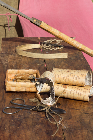 Scissors, rope, awl and birch's bark on wooden tableの写真素材